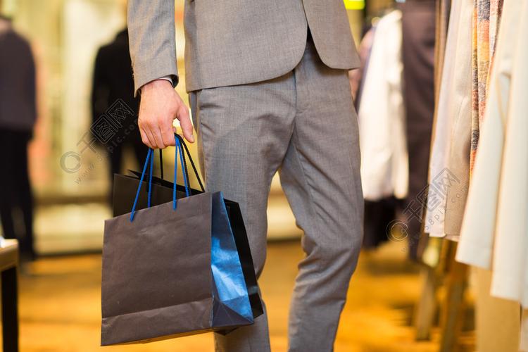 销售,时尚,零售,商业风格和人们观念-封闭的西装与购物袋在服装店里的